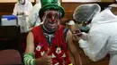 Seorang badut disuntik vaksin COVID-19 Sinopharm selama kampanye vaksinasi yang menargetkan usia antara 18 dan 30 tahun di Universitas Negeri San Andres di La Paz, Bolivia, Senin (5/7/2021). Presiden Luis Arce menjanjikan upaya vaksinasi "besar-besaran" pada Juli dan Agustus. (AP Photo/Juan Karita)