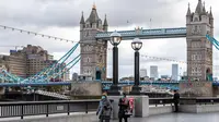 Orang-orang berjalan di tepi Sungai Thames di depan Tower Bridge, London, Inggris, pada 6 Oktober 2020. Inggris melaporkan 14.542 kasus terkonfirmasi baru COVID-19, menambah total infeksi di negara itu menjadi 530.113, menurut data resmi yang dirilis pada Selasa (6/10). (Xinhua/Han Yan)