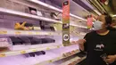 Pengunjung melihat rak-rak kosong di supermarket saat berbelanja makanan untuk persiapan menghadapi Badai Kompasu di Hong Kong, Selasa (12/10/2021). Observatorium Hong Kong mengeluarkan sinyal nomor 8, level tertinggi ketiga dalam skalanya, saat badai Kompasu semakin mendekat. (AP Photo/Vincent Yu)