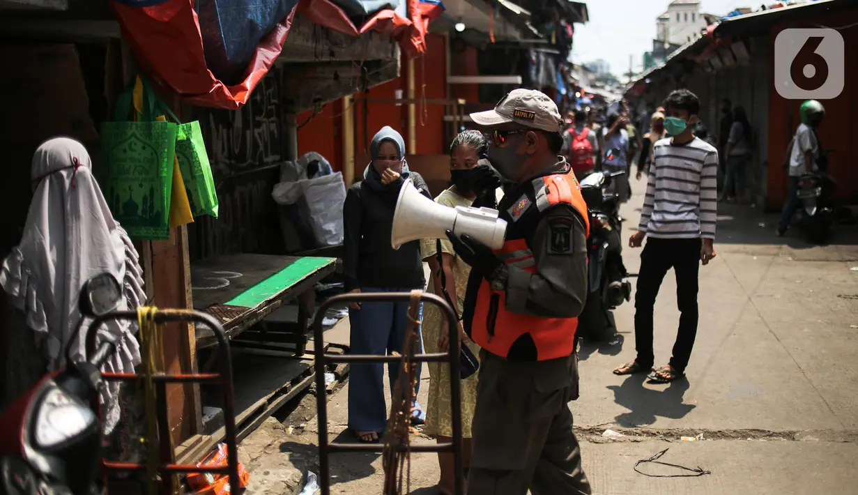 Petugas Satpol PP melakukan sosialisasi saat menertibkan pedagang yang nekat berjualan selama masa pandemi COVID-19 di kawasan Pasar Tanah Abang, Jakarta, Jumat (22/5/2020). Gubernur DKI Jakarta Anies Baswedan menambah PSBB selama 14 hari mulai tanggal 22 Mei 2020. (Liputan6.com/Faizal Fanani)