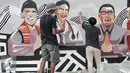 Sejumlah pekerja menyelesaikan mural di lokasi Taman Pandang Istana Jalan Medan Merdeka Utara, Jakarta, Jumat (29/7). Jelang diresmikan, Taman Pandang Istana di Jalan Medan Merdeka Utara mulai dihias. (Liputan6.com/Yoppy Renato)