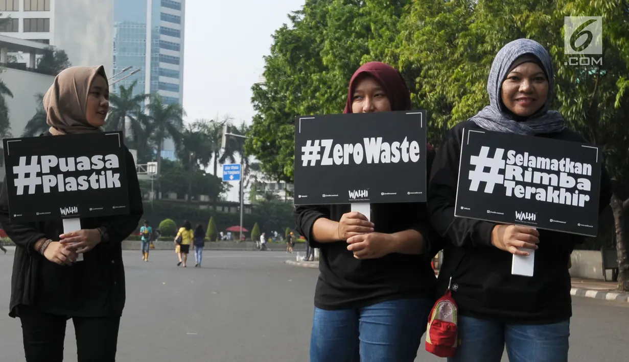 Aktivis Walhi berjalan sambil membawa tulisan mengampanyekan pengurangan penggunaan plastik di kawasan Bundaran Hotel Indonesia, Jakarta, Minggu (6/3). Mereka mengajak masyarakat mengurangi penggunaan plastik. (Liputan6.com/Helmi Fithriansyah)