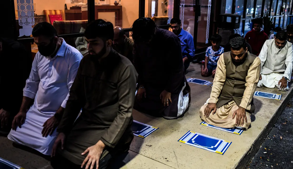 Pria Muslim melaksanakan salat di trotoar di luar restoran selama bulan suci Ramadhan di Lauderhill, Florida, Jumat (30/4/2021). Selama puasa Ramadhan, umat Islam tidak makan, minum, atau aktivitas seksual dari fajar hingga matahari terbenam. (CHANDAN KHANNA/AFP)