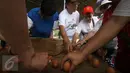 Sejumlah orang mencoba mendirikan telur pada Perayaan Peh Cun di pantai Parangtritis, Yogyakarta, Kamis (9/6). Setiap perayaan Peh Cun ada fenomena menarik, dimana sebutir telur dapat berdiri sendiri di atas bidang datar. (Liputan6.com/Boy Harjanto)
