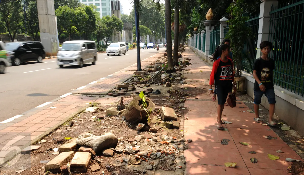 Pengguna jalan melintasi trotoar Jalan Asia Afrika, Jakarta, Selasa (24/5/2016). Pasca pembongkaran lapak pedagang tanaman pekan lalu, sisa pembongkaran masih terlihat dan membuat trotoar terlihat berantakan. (Liputan6.com/Helmi Fithriansyah)