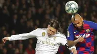 Gelandang Barcelona, Arturo Vidal, duel udara dengan bek Real Madrid, Sergio Ramos, pada laga La Liga 2019 di Stadion Camp Nou, Rabu (18/12). Kedua tim bermain imbang 0-0. (AP/Emilio Morenatti)