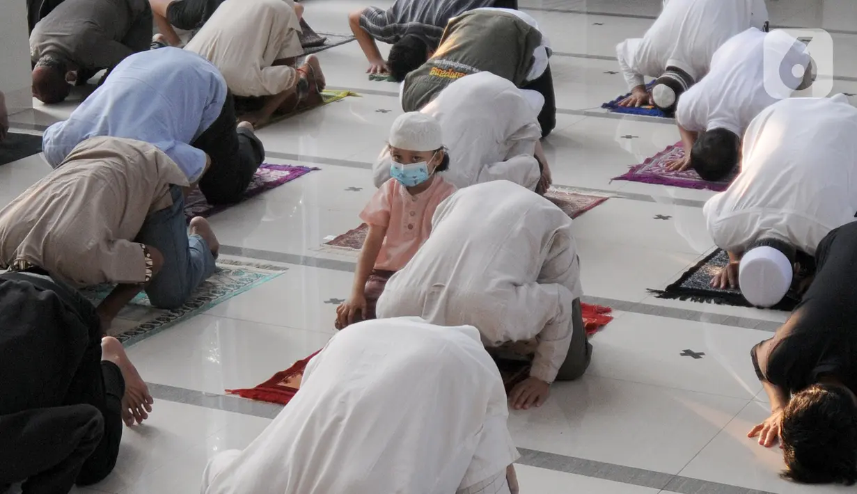Seorang anak melaksanakan salat Idul Adha 1442 H di Masjid Al-Madina Zona Madina, Parung, Bogor, Jawa Barat, Selasa (20/7/2021). Protokol kesehatan yang dilakukan di antaranya pengecekan suhu tubuh dan pengaturan jarak shaf salat. (merdeka.com/Arie Basuki)