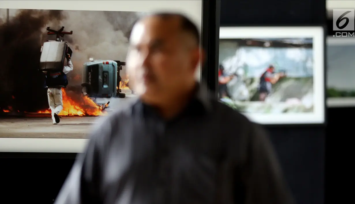 Pengunjung melihat foto-foto peristiwa Reformasi 1998 yang dipamerkan di Gedung Nusantara III, Jakarta, Jumat (11/5). Pameran ini untuk mengenang mereka yang gugur serta amanat perubahan yang belum terlaksana sempurna. (Liputan6.com/JohanTallo)