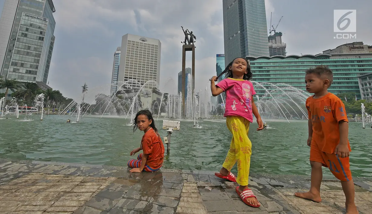 Sejumlah anak bermain air di kolam Bundaran HI, Jakarta, Senin (17/6/2019). Meski ada larangan berenang, sejumlah anak tetap nekat menyebur ke kolam Bundaran HI. (Liputan6.com/Herman Zakharia)