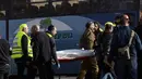 Petugas mengevakuasi jenazah dari lokasi serangan truk yang menabrak sejumlah tentara Israel di sebuah tempat wisata di Yerusalem, Minggu (8/1). Polisi setempat mengatakan tiga dari empat korban tewas adalah perempuan. (AP Photo/Mahmoud Illean)