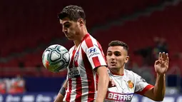 Penyerang Atletico Madrid, Alvaro Morata, berebut bola dengan bek Real Mallorca, Aleksandar Sedlar, pada laga lanjutan La Liga di Wanda Metropolitano, Sabtu (4/7/2020) dini hari WIB. Atletico Madrid menang 3-0 atas Mallorca. (AFP/Pierre-Philippe Marcou)