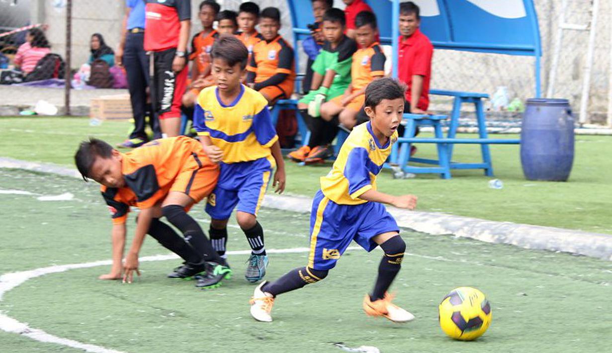 Pemain Indocement SS melewati hadangan pemain Tunas Patriot dalam laga U-11 Liga Bola Indonesia 2016 pekan ke-5 di Sabnani Park, Alam Sutera, Tangerang, Minggu (2/10/2016). (Bola.com/Liga Bola Indonesia)