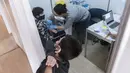 Seorang anak melihat temannya disuntik vaksin covid-19 oleh tenaga medis di ibu kota Siprus, Nicosia, Minggu (2/1/2022). Siprus memulai vaksinasi untuk anak-anak berusia antara 5 hingga 11 tahun, di tengah lonjakan tajam kasus virus corona. (Iakovos Hatzistavrou / AFP)
