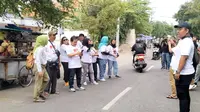 Relawan Tifosi Ganjar Pranowo (Tegap) membagikan atribut Ganjar Pranowo kepada pengguna jalan di kawasan Diponegoro  Surabaya. (Istimewa).