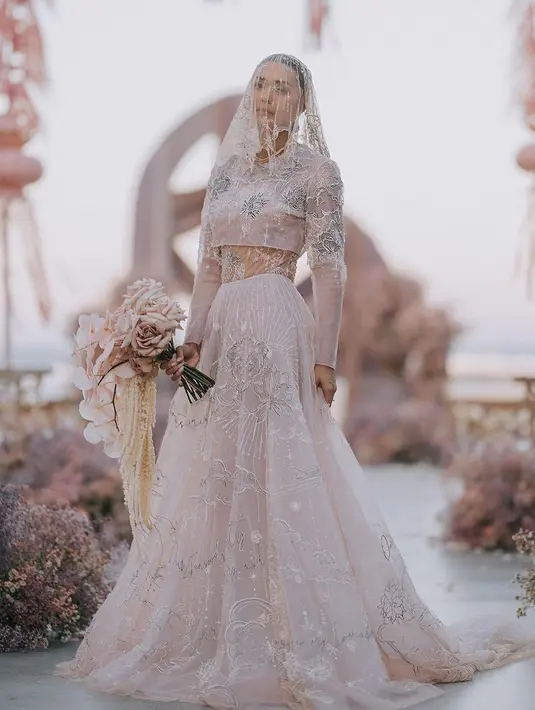 Gaun pengantin Adinia Wirasti memang tak kalah unik. Pasalnya, ia memilih gaun pengantin bernuansa merah muda yang lembut rancangan Mel Ahyar. [Foto: Instagram/melahyarbride]