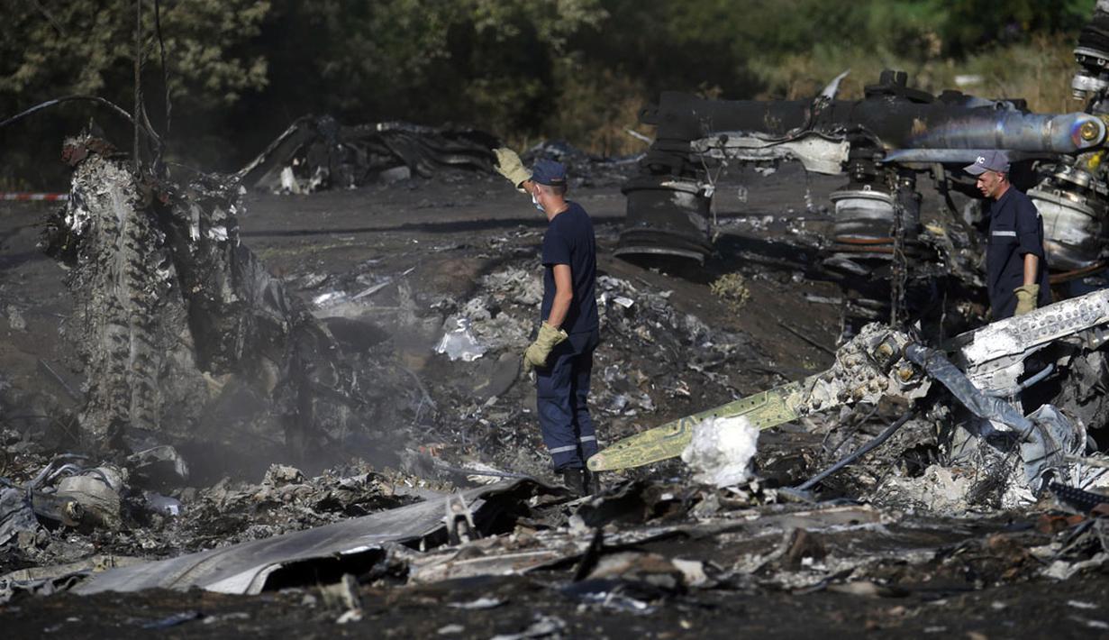 Anggota Kementerian Darurat Ukraina mencari bukti baru jatuhnya pesawat Malaysia Airlines MH-17 diantara sisa puing-puing di desa Hrabove, Donetsk, Ukraina, (20/7/2014). (REUTERS/Maxim Zmeyev)