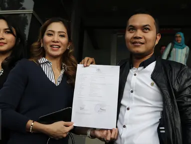 Aktris Bunga Zainal memperlihatkan surat laporan di Polda Metro Jaya, Jakarta, Senin (27/2). Bunga Zainal mengaku jadi korban penipuan terkait foto dirinya yang digunakan tanpa sepengetahuan dirinya. (Liputan6.com/Herman Zakharia)