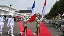 Prajurit TNI AD membawa bendera negara sebelum kunjungan Menteri Angkatan Bersenjata Prancis Florence Parly di Kementerian Pertahanan di Jakarta, Kamis (10/2/2022). (AFP/Adek Berry)