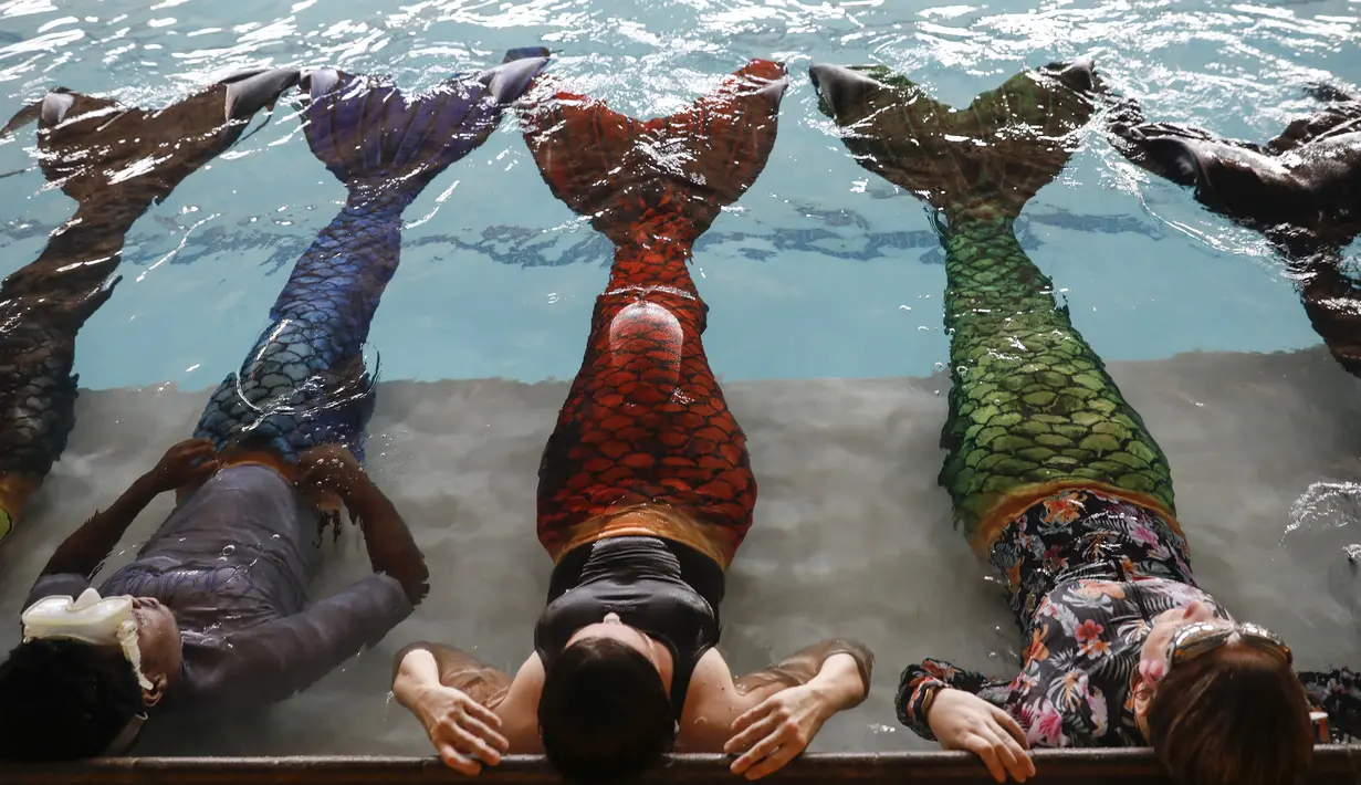 Siswa melakukan rutinitas selama kelas putri duyung mereka di Merschool di Kayalami, dekat Midrand, Afrika Selatan pada 3 Juni 2022. - Mermaiding adalah olahraga yang berkembang pesat di seluruh dunia dan mencakup beberapa keterampilan seperti berenang monofin, mengayuh, trik, dan menahan napas. (Phill Magakoe / AFP)
