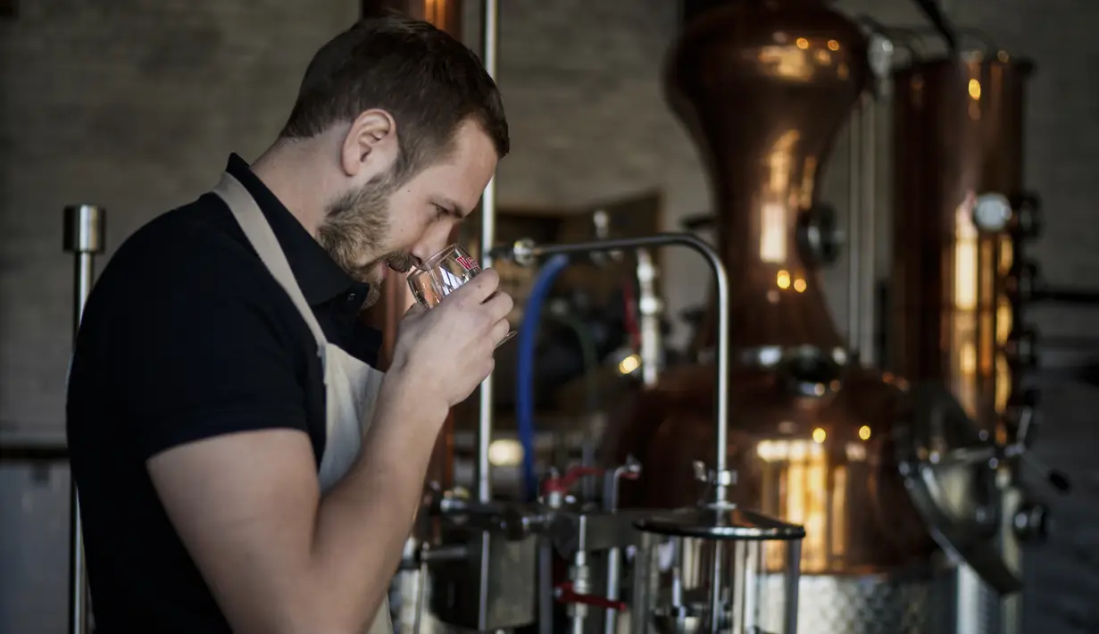 Manajer Waterloo Microdistillery, Edward Martin bekerja di Mont-Saint-Jean Farm, Waterloo, Belgia, Selasa (7/4/2020). Di tengah pandemi virus corona COVID-19, pabrik sopi dan wiski Mont-Saint-Jean Farm beralih memproduksi alkohol medis. (Kenzo TRIBOUILLARD/AFP)