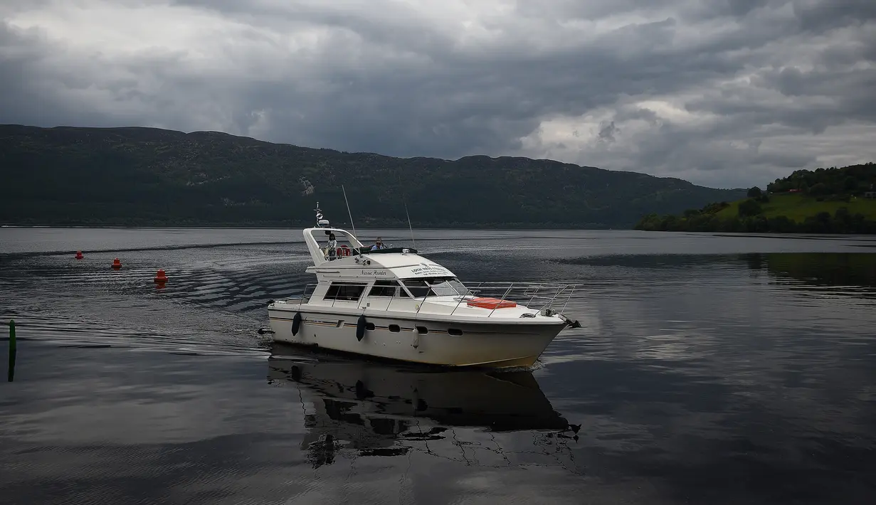 Kapal turis 'Nessie Hunter' melintas di perairan Loch Ness, Drumnadrochit, Skotlandia, 10 Juni 2018. Hasil dari penelitian para ilmuwan terkait monster raksasa Loch Ness di perairan tersebut menyimpulkan memang ada sesuatu di wilayah itu. (Andy Buchanan/AFP)