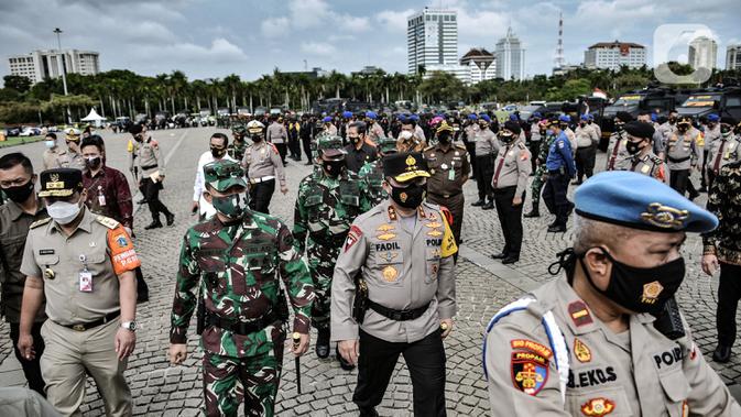 Kapolda Metro Jaya Irjen Pol Muhammad Fadil Imran didampingi Pangdam Jaya Mayjen TNI Dudung Abdurachman dan Wakil Gubernur Riza Patria meninjau barisan pasukan saat apel Operasi Lilin Jaya 2020 di Lapangan Silang Monas, Jakarta, Senin (21/12/2020). (merdeka.com/Iqbal S. Nugroho)
