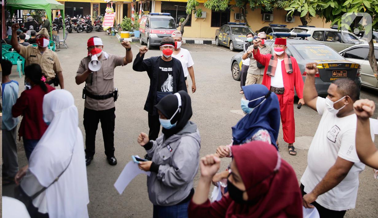 Petugas kepolisian berpakaian pejuang jaman dulu saat memberikan pengarahan kepada warga yang akan ikut vaksin Covid-19 di Polsek Pasar Rebo, Jakarta, Selasa (17/8/2021). Para petugas berkostum pejuang jaman dulu memeriahkan HUT ke-76 Republik Indonesia. (Liputan6.com/Angga Yuniar)