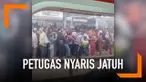Desakan antrean di peron stasiun membuat seorang petugas nyaris jatuh ke rel kereta.