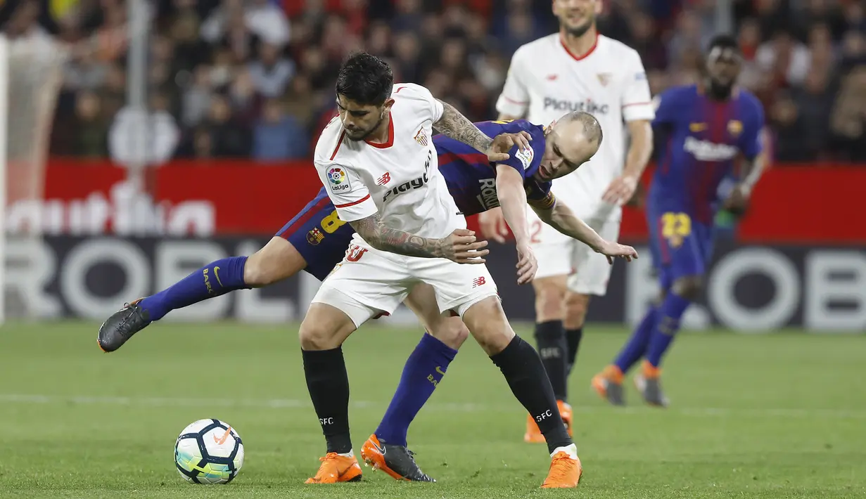 Aksi pemainBarcelona, Andres Iniesta (belakang) saat berebut bola dengan pemain Sevilla, Banega pada laga La Liga Santander di Sanchez Pizjuan stadium, (31/3/2018). Barcelona bermain imbang 2-2 dengan Sevilla. (AP/Miguel Morenatti)
