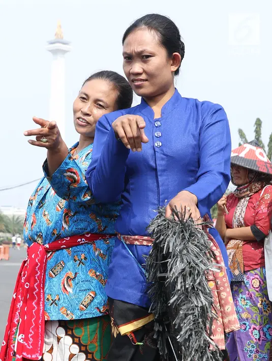 Dua perempuan Kendeng bersiap menari saat aksi di depan Istana Negara, Jakarta, Kamis (2/8). Dalam aksinya, mereka melakukan tradisi Brokohan memperingati pertemuan mereka dengan Presiden Jokowi. (Liputan6.com/Helmi Fithriansyah)