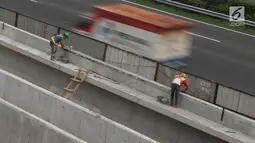 Pekerja menyelesaikan pembangunan proyek kereta ringan (LRT) di kawasan Kampung Makassar, Jakarta, Rabu (19/7). Gubernur DKI Jakarta Djarot Saiful Hidayat meminta agar sarana transportasi masal MRT dan LRT berkoordinasi. (Liputan6.com/Immanuel Antonius)