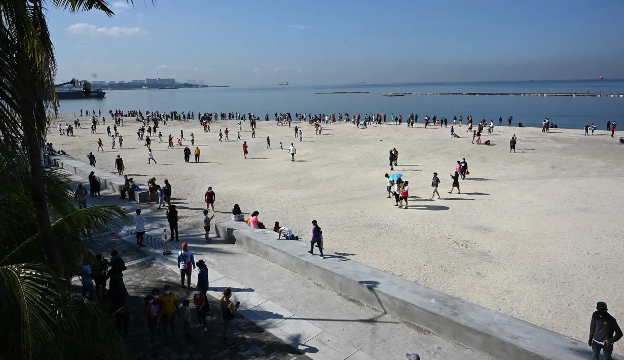 Pemandangan orang-orang yang berkumpul di Manila baywalk dolomite beach di sepanjang boulevard Roxas, kota Manila, Filipina pada Minggu (17/10/2021). Sehari sebelumnya, pihak berwenang melonggarkan pembatasan karantina di ibu kota negara itu. (Ted ALJIBE / AFP)