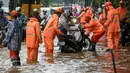 Petugas PPSU membantu pengedara motor yang mogok di jalan Lenteng Agung, Jakarta, Jumat (12/2). Banjir di jalan Lenteng Agung ketinggian airnya hingga 30-50cm. (Liputan6.com/Yoppy Renato)
