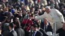 Paus Fransiskus menyapa khalayak dari mobil kepausan saat tiba untuk audiensi umum mingguan di Lapangan Santo Petrus pada tanggal 16 November 2016 di Vatikan. (ALBERTO PIZZOLI/AFP)