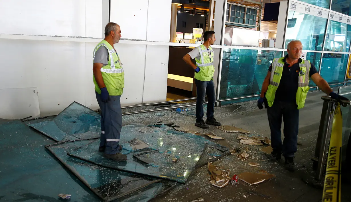 Pekerja membersihkan pecahan kaca yang berserakan usai terjadinya ledakan bom di bandara Ataturk, Istanbul, Rabu (29/6). Ledakan bom bunuh diri tersebut menghancurkan sebagian ruangan di bandara internasional terbesar di Turki ini. (REUTERS/Osman Orsal)