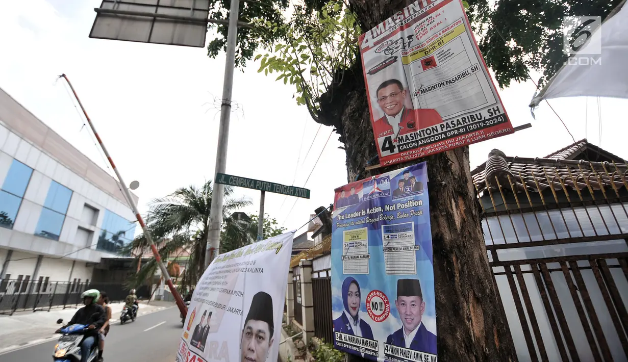 Sejumlah alat peraga kampanye (APK) calon anggota legislatif (caleg) memenuhi pepohonan yang berada di pinggir jalan, Jakarta, Rabu (20/3). Pemasangan APK caleg tersebut juga dapat merusak pepohonan serta lingkungan. (merdeka.com/Iqbal Nugroho)