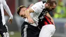 Gelandang AC Milan, Samu Castillejo berebut bola dengan bek Juventus, Giorgio Chiellini saat bertanding pada lanjutan Liga Serie A Italia di stadion San Siro, Milan (11/11). Juventus menang 2-0 atas AC Milan. (AP Photo / Luca Bruno)