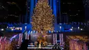 Lebih dari 50.000 lampu menghiasi Pohon Natal Rockefeller Center setinggi 75 kaki pada upacara tahunan pencahayaan di New York, Rabu (2/11/2020). Upacara yang digelar pada masa pandemi COVID-19 ini mewajibkan pengunjung untuk memakai masker, pembatasan waktu, dan jaga jarak. (AP Photo/Craig Ruttle)