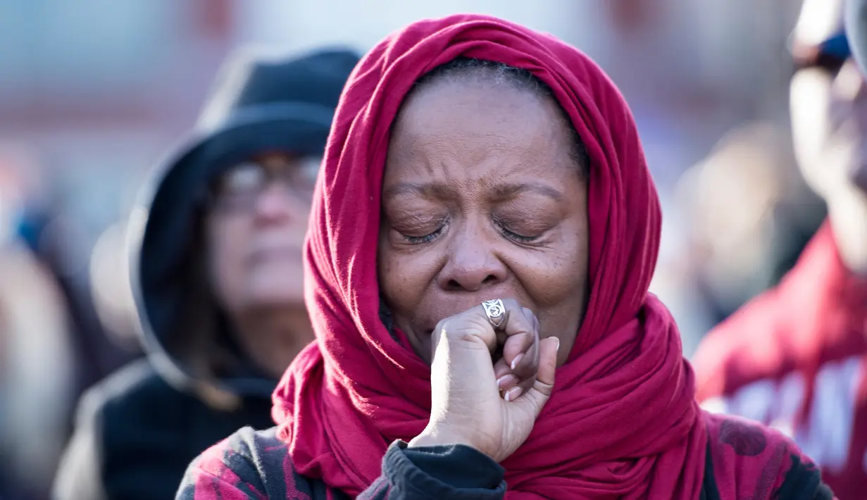 Seorang wanita mendengarkan lonceng saat menghadiri peringantan 50 tahun pembunuhan Martin Luther King Jr di Memphis, Tennessee (4/4). Martin Luther King Jr ditembak di balkon kamarnya di lantai dua Motel Lorraine di Memphis. (AFP/Brendan Smialowski)