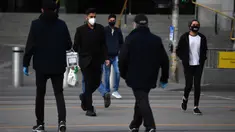 Orang-orang yang memakai masker berjalan di luar Stasiun Flinders Street di Melbourne, Kamis (23/7/2020). Sebagian penduduk kota terpadat kedua di Australia, Melbourne, mematuhi undang-undang baru yang mewajibkan pemakaian masker. (James Ross / AAP Image via AP)