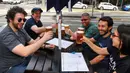 Pelanggan menikmati bir di sebuah pub di Melbourne, Australia, Jumat (22/10/2021). Kota terbesar kedua di Australia ini kembali dibuka setelah mengalami salah satu rangkaian lockdown pandemi yang paling lama di dunia. (William WEST/AFP)