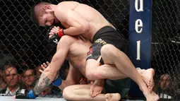 Khabib Nurmagomedov saat mengunci Conor McGregor dalam pertarungan UFC 229 di Las Vegas, AS (6/10). Nurmagomedov dinyatakan menang melalui submission. Dia melakukan rear naked choke kepada McGregor. (AP Photo/John Locher)