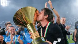 Pelatih Napoli, Antonio Conte, mencium trofi Serie A saat selebrasi juara Liga Italia musim 2024/2025 di Stadion Diego Armando Maradona, Sabtu (24/5/2025). (AP Photo/Gregorio Borgia)