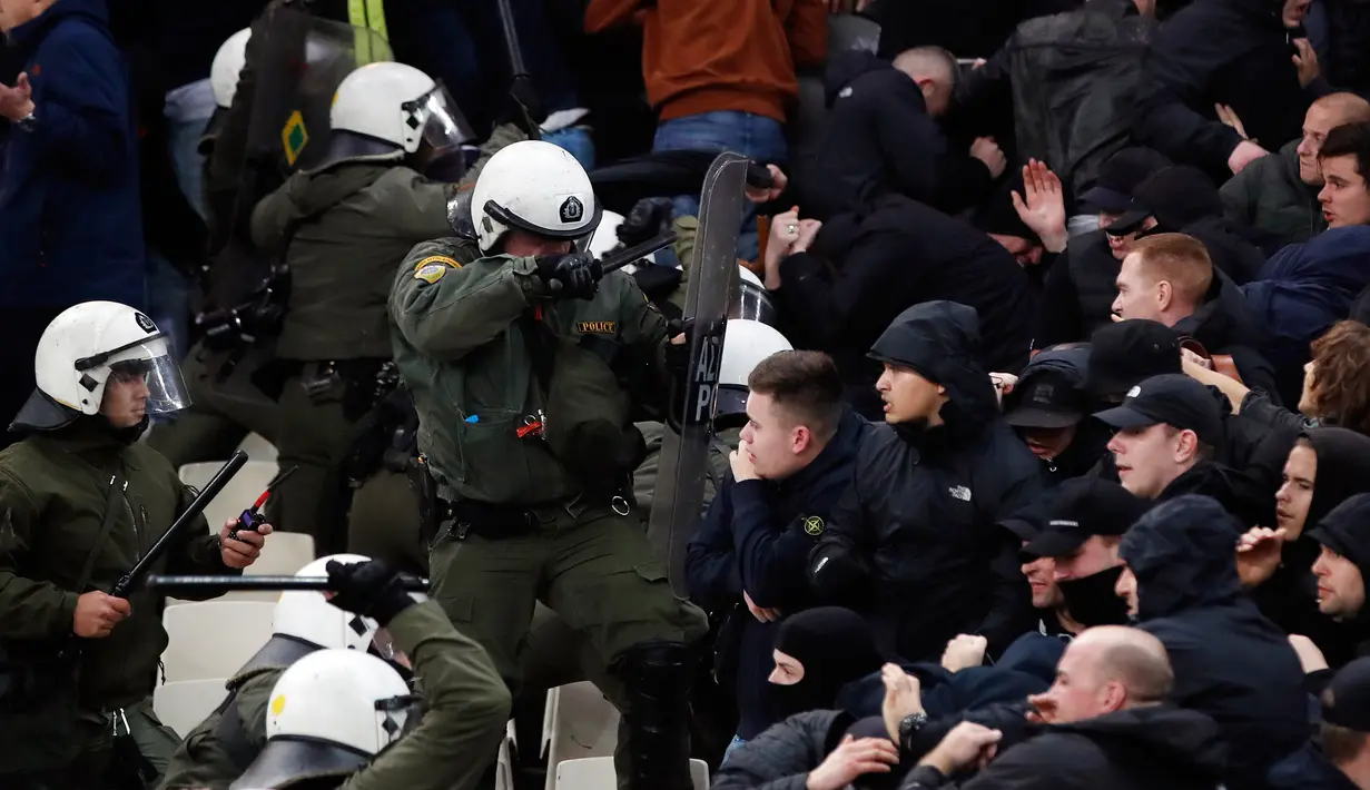 Polisi anti huru-hara Yunani bentrok dengan suporter Ajax Amsterdam sebelum pertandingan Liga Champions melawan AEK Athena di Stadion Olimpiade Athena, Selasa (27/11). Akibat bentrokan ini, sejumlah pendukung Ajax terluka. (AP/Thanassis Stavrakis)