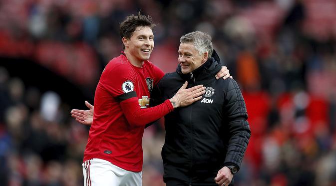 Bek Manchester United (MU) Victor Lindelof dan manajer Ole Gunnar Solskjaer tersenyum usai mengalahkan Watford 3-0 pada pekan ke-27 Liga Inggris di Old Trafford, Minggu (23/2/2020). (Martin Rickett / PA via AP)