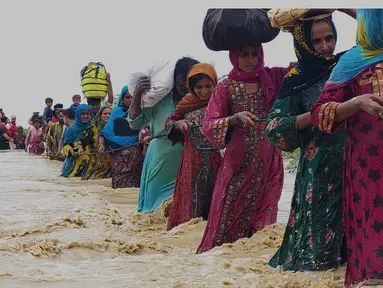 Petugas penyelamat membantu penduduk desa untuk mengevakuasi mereka dari daerah banjir yang disebabkan hujan lebat, di Lasbella, sebuah distrik di provinsi Baluchistan barat daya Pakistan (26/7/2022). Para pejabat mengatakan, pada hari Rabu, penyelamat yang didukung oleh pasukan menggunakan perahu dan helikopter untuk mengungsi ratusan orang terdampar dari barat daya Pakistan, di mana banjir yang dipicu oleh hujan telah menewaskan 104 orang sejak bulan lalu. (AP Photo/Hamdan Khan)