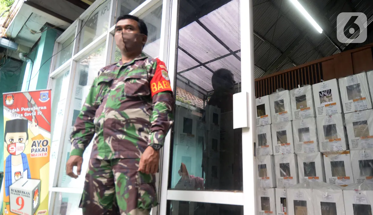 Tentara berdiri menjaga kotak hasil rekapitulasi penghitungan suara di TPS tingkat kelurahan di Kecamatan Pamulang, Tangerang Selatan, Banten, Kamis (10/12/2020). Proses rekapitulasi suara ditunda sementara karena terkendala jaringan ke server KPU Pusat down. (merdeka.com/Dwi Narwoko)