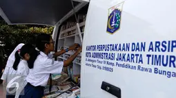 Sejumlah siswa memilih buku bacaan dari mobil perpustakaan keliling di halaman sekolah, Jakarta, Jumat (4/9/2015). Sebelumnya sekolah SMPN 49 mengalami kebakaran dan menyebakan ruangkan perpustakaan ludes terbakar. (Liputan6.com/Yoppy Renato)