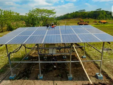 Petani membersihkan panel surya yang dipasang pada areal pertanian di Cikaduwetan, Kabupaten Kuningan, Jawa Barat, Rabu (23/8/2023). (merdeka.com/Arie Basuki)