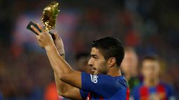 Striker Barcelona, Luis Suarez, menunjukan Sepatu Emas jelang laga La Liga melawan Granada di Stadion Nou Camp, Spanyol, Sabtu (29/10/2016). Suarez meraih gelar ini usai mencetak 40 gol pada musim lalu. (Reuters/Albert Gea)